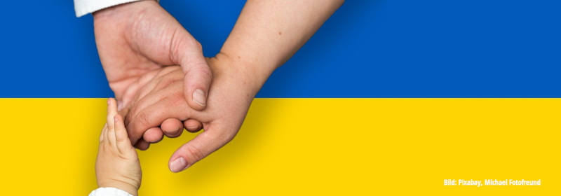 Hände vor ukrainischer Flagge